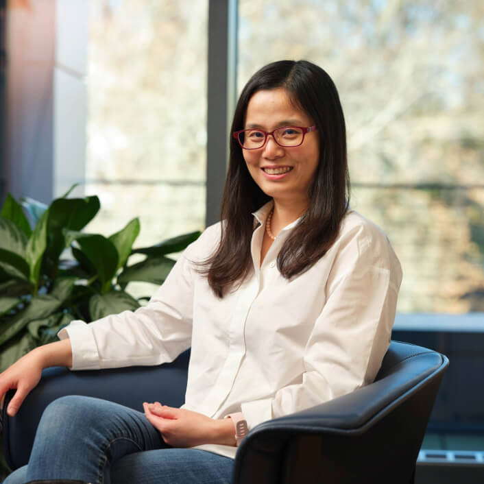 Portrait of woman in green jackt in office setting.