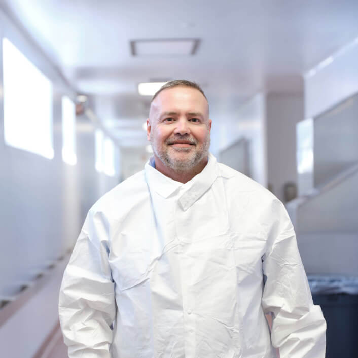 Smiling man in lab coat at Alkermes office.
