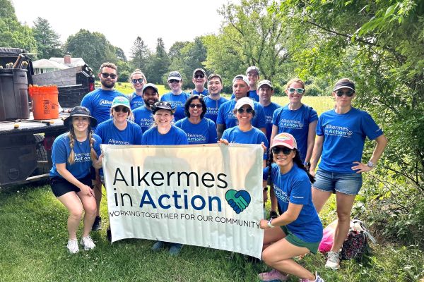 group of employees holding a banner that reads Alkermes in Action