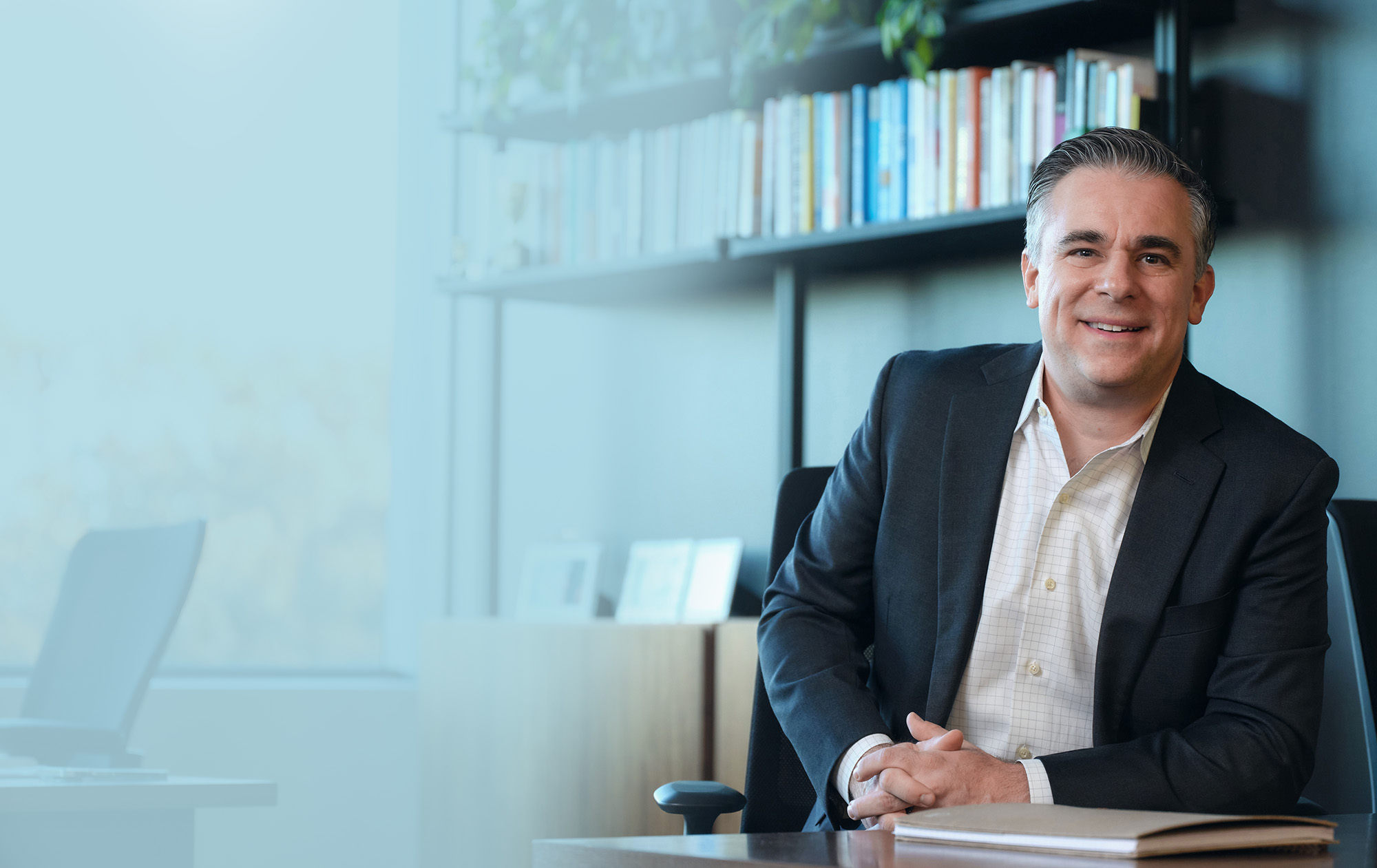 Portrait of Stephen Schiavo at table smiling.