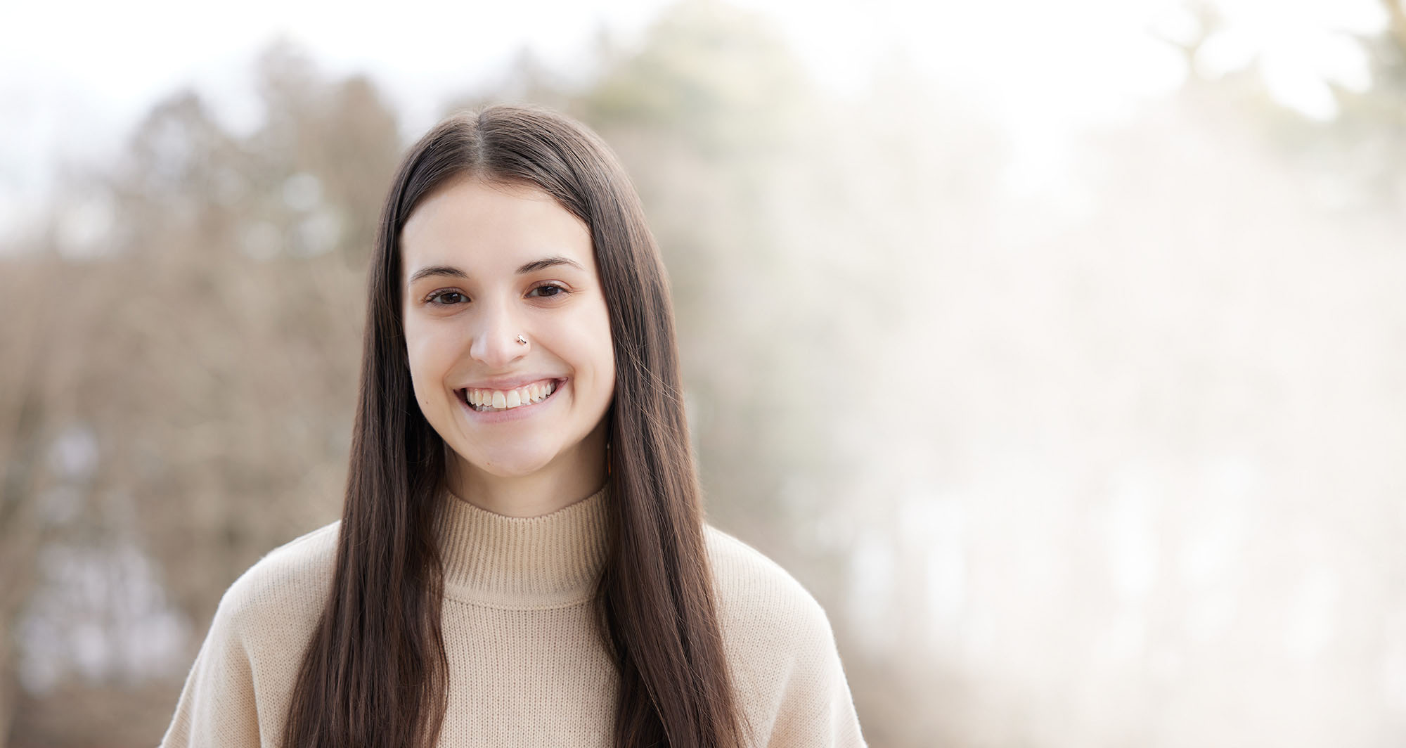 Smiling man with glasses sitting at table in Alkermes conference room with window in background