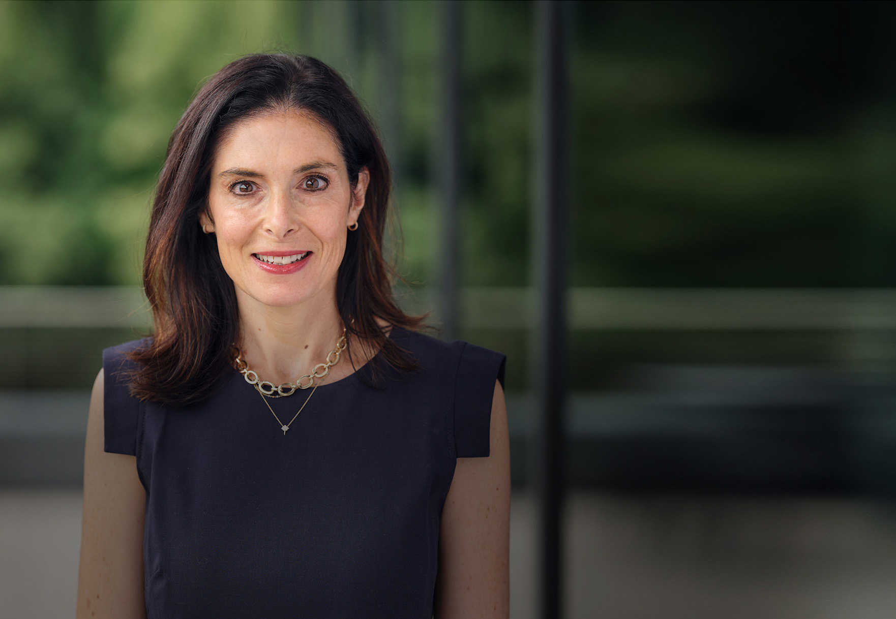 Smiling man with glasses sitting at table in Alkermes conference room with window in background