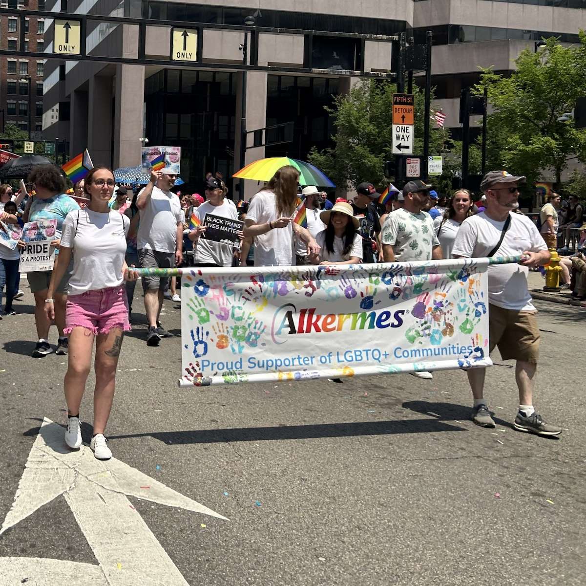 People walking with a banner that says Alkermes Proud Supporter of LGBTQ+