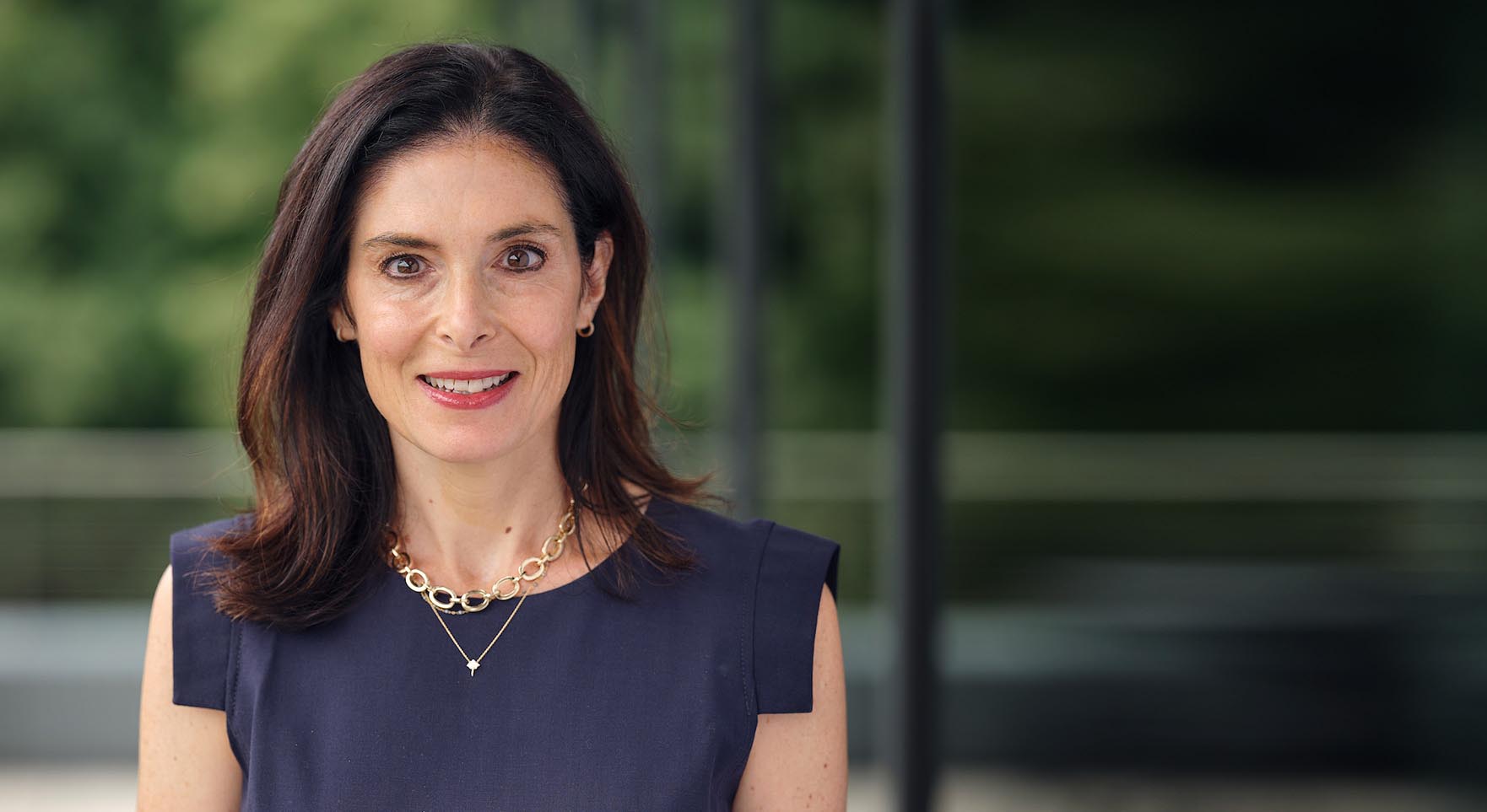 Smiling man with glasses sitting at table in Alkermes conference room with window in background