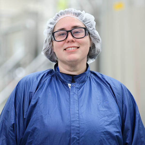 Man in blue shirt standing in hallway with yellow walls at Alkermes